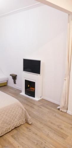a bedroom with a fireplace and a tv on a wall at Burano Cà Comare in Burano