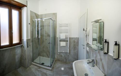 La salle de bains est pourvue d'une douche en verre et d'un lavabo. dans l'établissement RobHouse, à Passo Corese