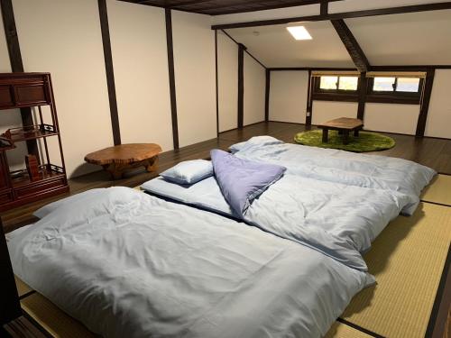 una stanza con tre grandi letti bianchi di Guesthouse Shin a Omihachiman