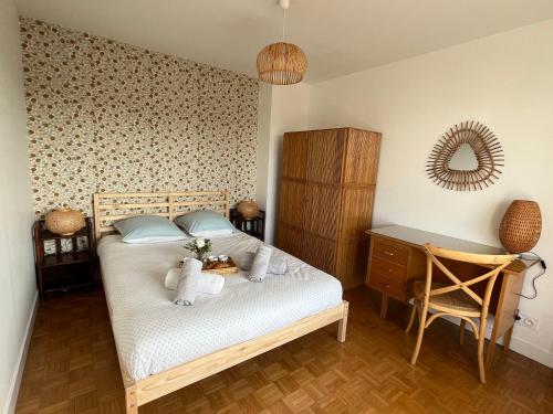 um quarto com uma cama, uma secretária e um espelho em Cocon vintage - T4 central et lumineux em Annecy