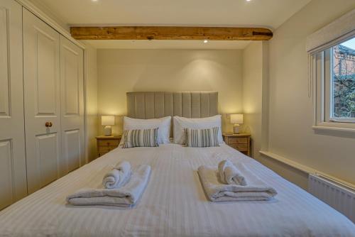a bedroom with a large bed with towels on it at Host & Stay - Gleanings in Bredon