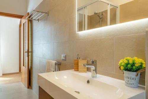 y baño con lavabo y espejo. en [LA SERENA] large apartment with wifi, a/c, private parking, en Acquaseria
