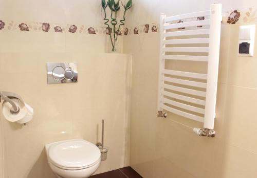 a bathroom with a white toilet and a staircase at Hotel Dukat in Biała Podlaska