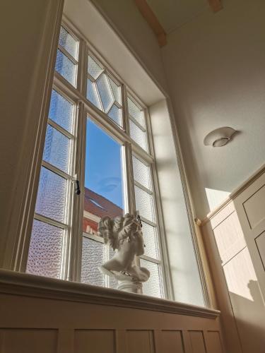 a window with a statue in front of it at Villa Deichvoigt in Cuxhaven