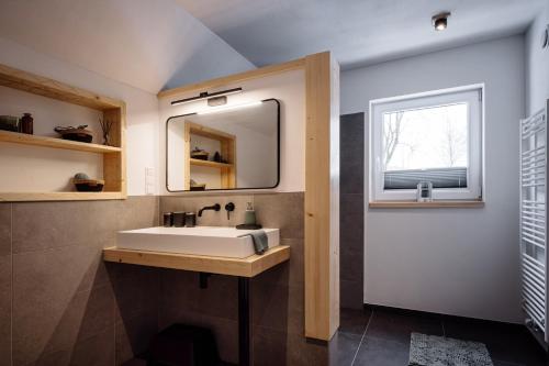 baño con lavabo, espejo y ventana en Urlaub am Schwarzbach mit Sauna und Whilpool en Butgenbach