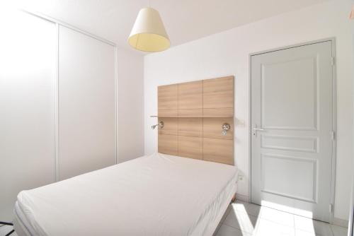 a white bedroom with a bed and a closet at T2 Résidence Cap Camargue avec piscine in Le Grau-du-Roi