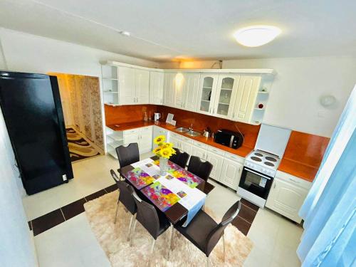 a kitchen with a table and chairs and a kitchen with white cabinets at Rebeka 2 in Nyíregyháza