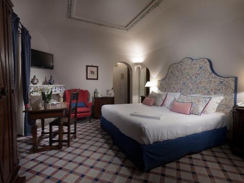 a bedroom with a large bed and a table and a desk at Hotel Villa Cimbrone in Ravello