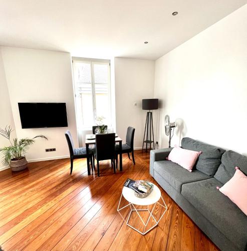 a living room with a couch and a table at HYPER CENTRE - Colmar Cathédrale - PARKING Gratuit in Colmar