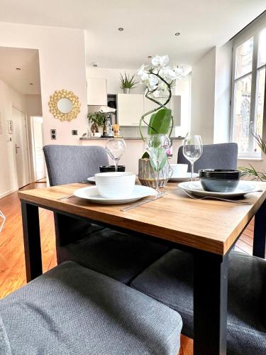 a dining room table with two chairs and a table with glasses at HYPER CENTRE - Colmar Cathédrale - PARKING Gratuit in Colmar