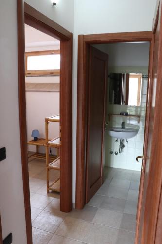 baño con puerta y lavabo en una habitación en Agriturismo Villaggio Eden, en Pieve Santo Stefano