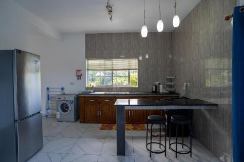 a kitchen with a counter and some stools in it at Creole Cottage Apartment in Anse Royale