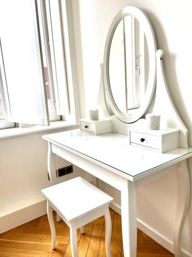a white dressing table with a mirror and a stool at HYPER CENTRE - Colmar Cathédrale - PARKING Gratuit in Colmar