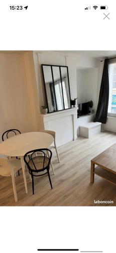 een tafel en stoelen in een woonkamer met een tafel en een eetkamer bij Appartement centre ville in LʼAigle