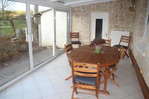 gite du lincret في Frencq: غرفة طعام مع طاولة وكراسي خشبية