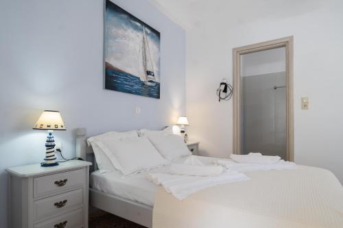 um quarto branco com uma cama com lençóis e almofadas brancos em Giasemi Room No 7 Irakleia em Livadi Astypalaias