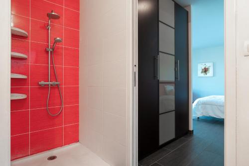 uma casa de banho com um chuveiro com azulejos vermelhos em Le Fusain - Maison climatisée pour 6 em Pont-Aven