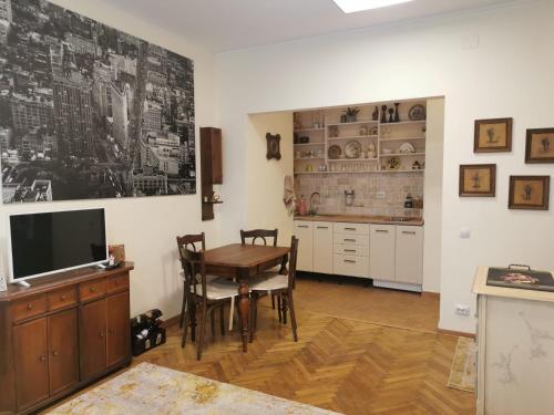 a dining room with a table and a tv at Angels' Whisper - Studio City Center in Braşov