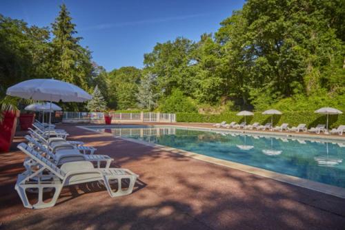 a row of chairs and umbrellas next to a swimming pool at Mobil home confort 6 personnes in Saint-Chéron