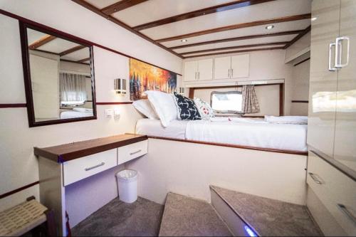 a small room with a bed and a desk and a mirror at HKA NETA YACHTING in Göcek