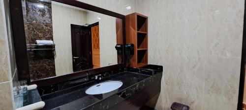 a bathroom with a sink and a large mirror at Gili Beachfront Suites in Gili Trawangan