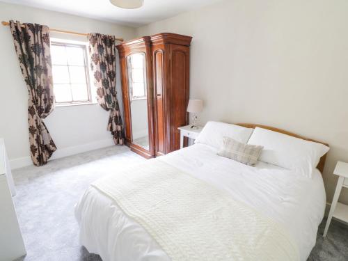 a bedroom with a white bed and a window at Millvale Cottage in Cootehill