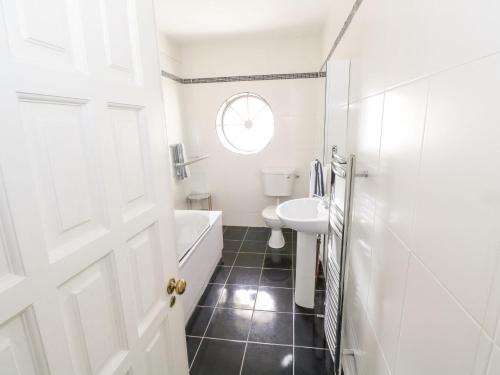 een badkamer met een wastafel, een bad en een toilet bij Millvale Cottage in Cootehill