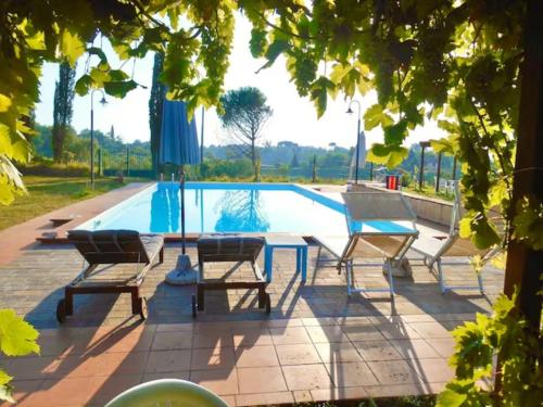 um grupo de cadeiras sentadas ao lado de uma piscina em Agriturismo La Pineta em Fucecchio