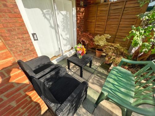 a patio with two chairs and a table at Luxurious House near Excel- Air Conditioning, 9 Beds, 2 Baths, Garden, fast WiFi in London