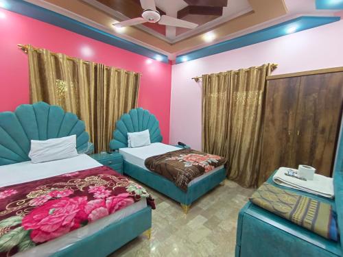 een kamer met 2 bedden en 2 stoelen bij Sk Travellers Inn in Karachi