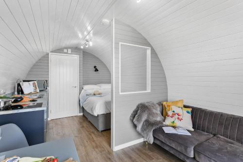 a living room with a couch and a bed at Bramley, Apple Tree Glamping, Nr Wells in Wells