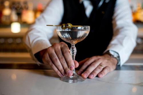 a man in a tuxedo holding a martini glass at InterContinental Perth City Centre by IHG in Perth