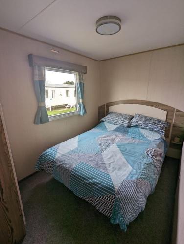 een slaapkamer met een bed en een raam bij Haven Holiday Home Littlesea Sleeps 6 in Weymouth