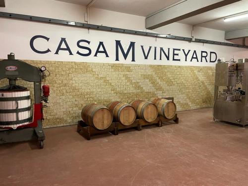 a row of wine barrels in a room with a sign at Casa M Tuscany in Chianciano Terme