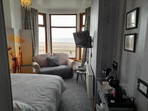 um quarto com uma cama, um sofá e uma televisão em The Fame em Blackpool