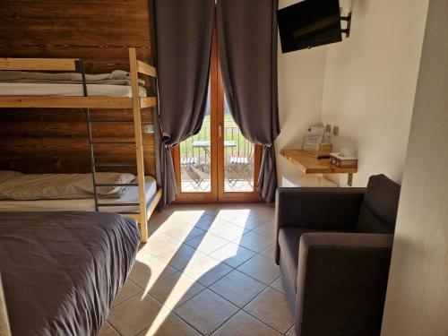 ein Schlafzimmer mit einem Etagenbett und einem Sofa in der Unterkunft Azienda Agricola Agriturismo I Sei Petali in Capo di Ponte
