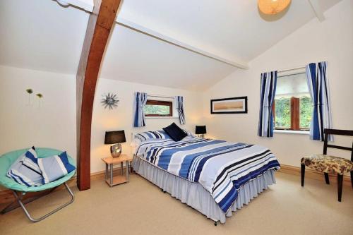 a bedroom with a bed and a chair in it at Betws Y Coed Serviced Holiday Home in Betws-y-coed