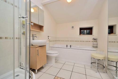 a bathroom with a sink and a toilet and a shower at Betws Y Coed Serviced Holiday Home in Betws-y-coed