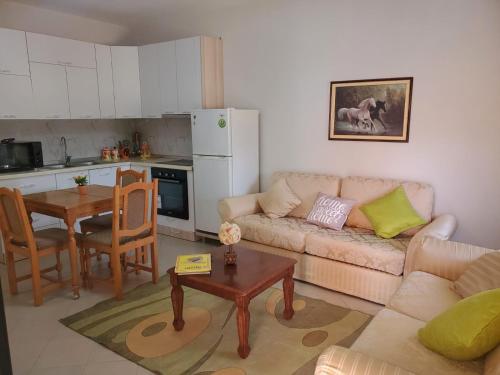 ein Wohnzimmer mit einem Sofa und einem Tisch in der Unterkunft Apartament 1+1 Plazh Durrës in Durrës