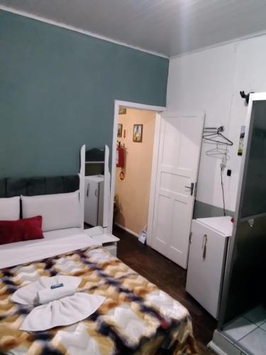 mały pokój z łóżkiem i drzwiami w obiekcie Pousada Jardim Alameda w mieście Blumenau