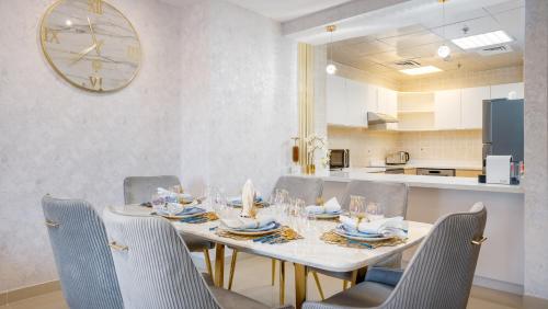 杜拜的住宿－Exclusive Retreat GLOBALSTAY's New 3BR Townhouse with Private Pool，餐桌、椅子和墙上的时钟