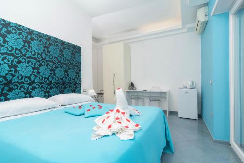 a bedroom with a blue bed with a towel on it at Guest House Emily Suites Sorrento in Sorrento