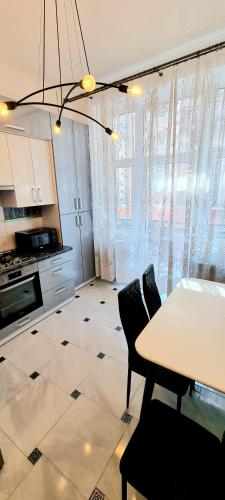 a kitchen with a table and chairs in a room at Центр Апарт in Ternopilʼ