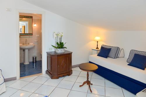 a room with a bed and a sink and a table at Hotel Villa Cimbrone in Ravello