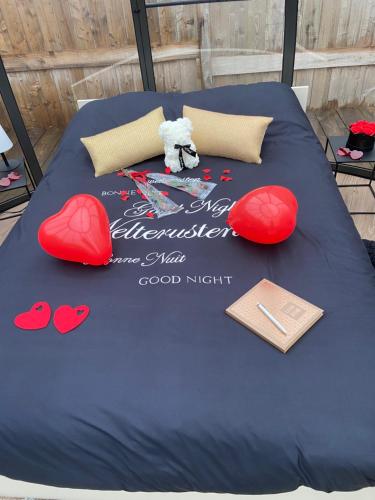 a bed with hearts and a book on it at Home Sweet Dôme in Bouillon in Noirefontaine