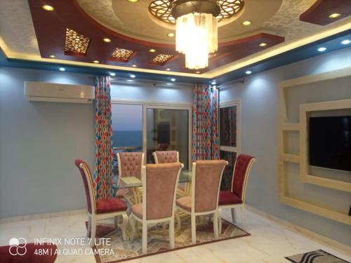 a dining room with a table and chairs and a tv at ستانلي اسكندريه in Alexandria