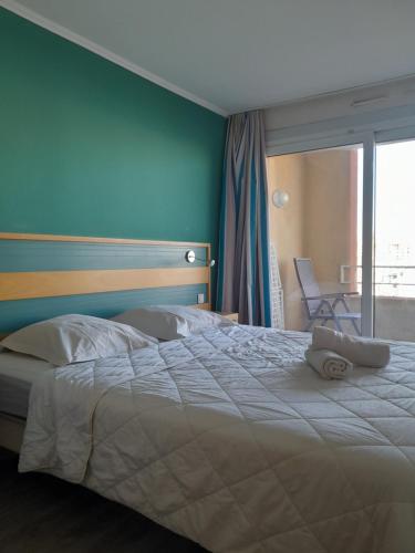 una camera con un grande letto con una parete blu di Port Frejus Thalasso a Fréjus