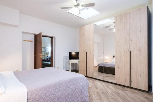 Schlafzimmer mit einem weißen Bett und einem Spiegel in der Unterkunft House Under the Tower by Studio Vita in Bologna