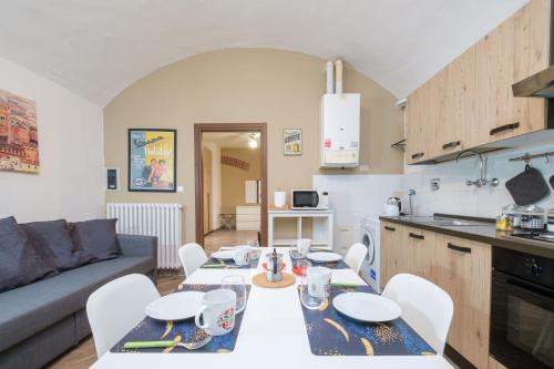 a kitchen and a living room with a table and chairs at House Under the Tower by Studio Vita in Bologna
