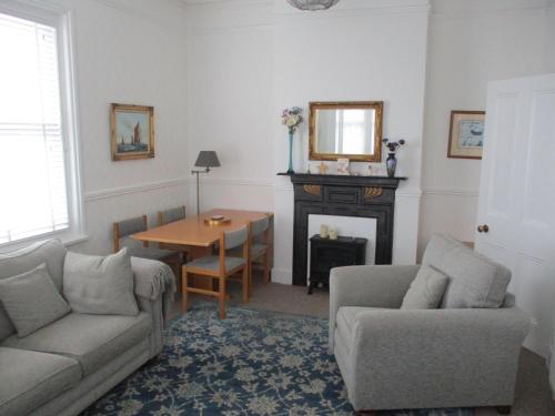 un soggiorno con divano e tavolo di Lovely Spacious 3 Bedded First Floor Apartment a Ryde